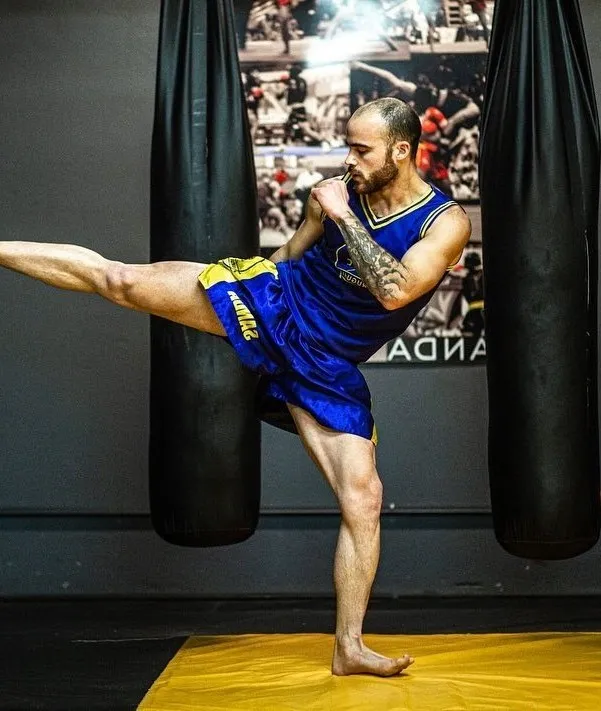 Dos luchadores de Sanda en un combate dinámico, mostrando técnicas de striking y derribos
